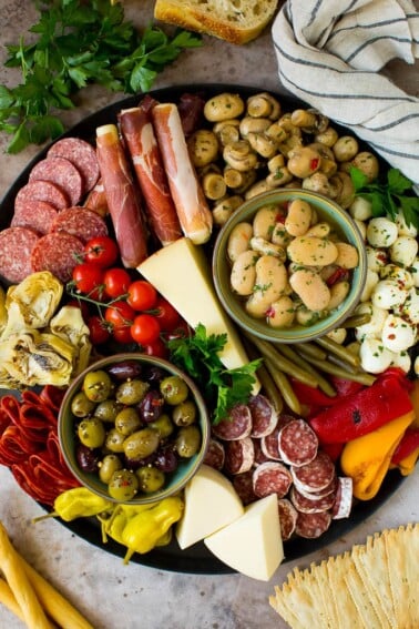 An antipasto platters with meats, cheeses, olives and vegetables.
