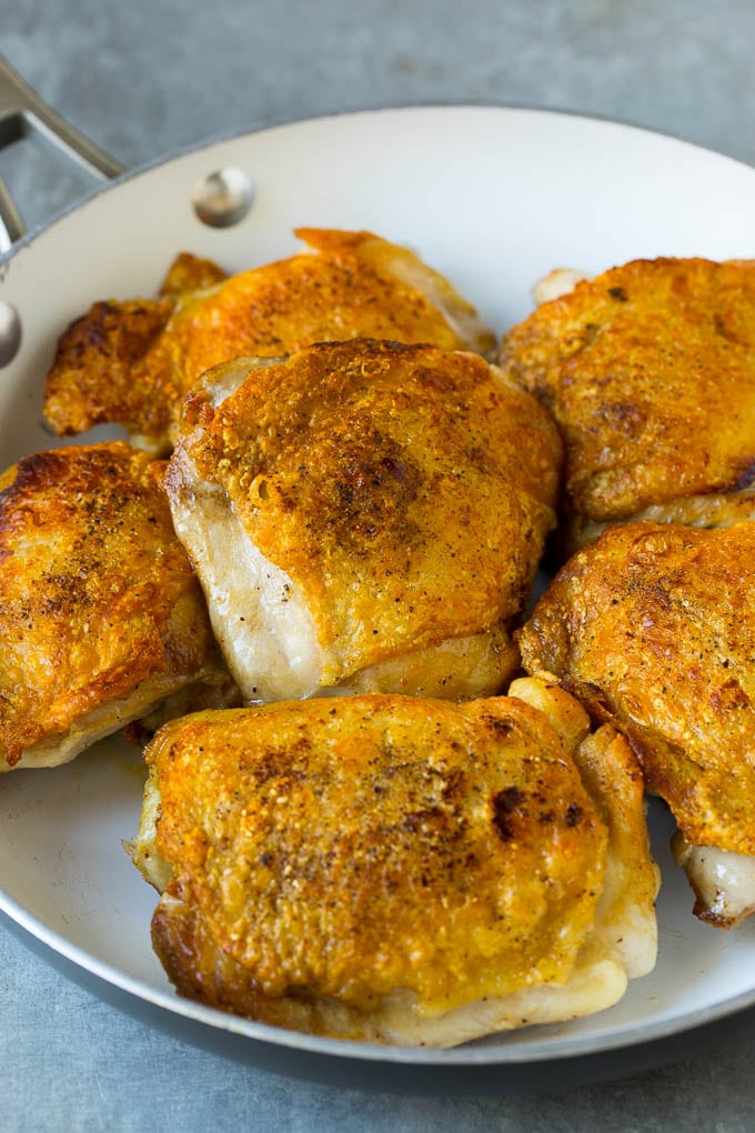 Seared chicken thighs in a pan.