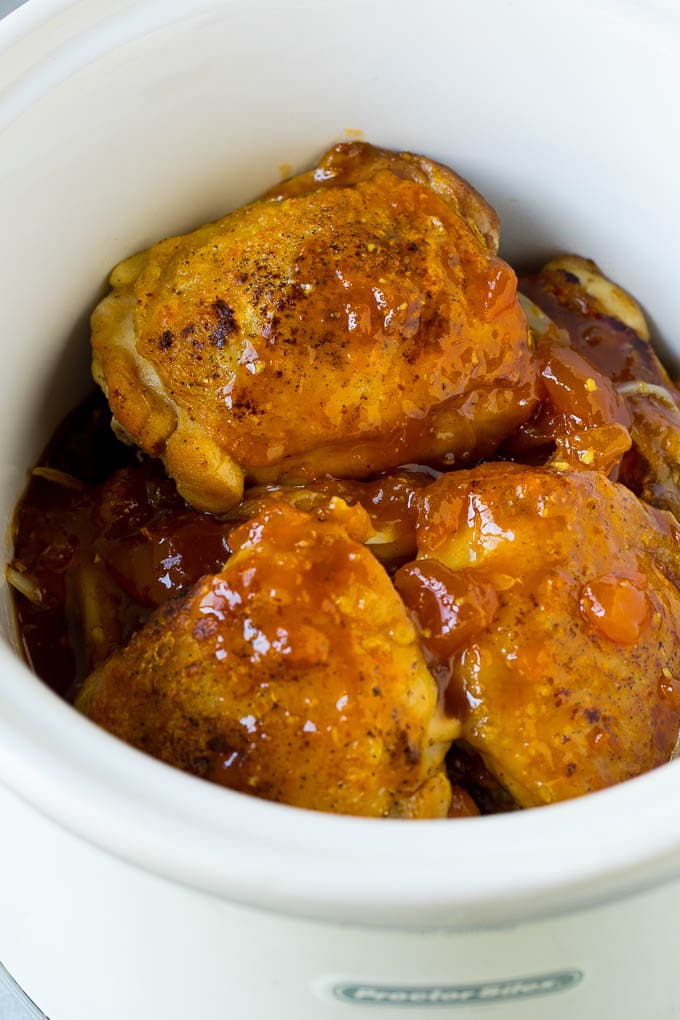 Chicken thighs in a slow cooker topped with a mixture of apricot jam, soy sauce and ginger.