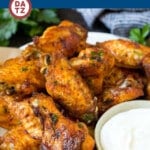 A plate of baked chicken wings which are coated in a homemade spice rub, then roasted to crispy perfection.