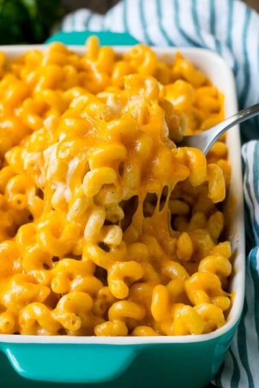 Baked mac and cheese with a serving spoon lifting up a portion.