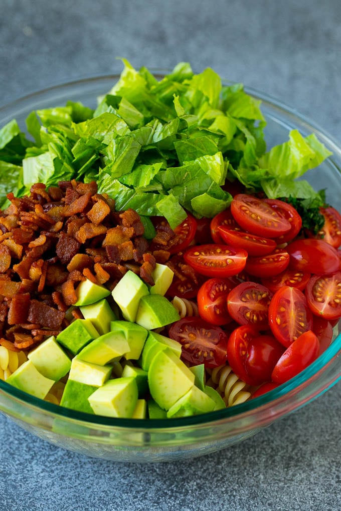 Bacon, lettuce, tomato, pasta and avocado in a bowl.
