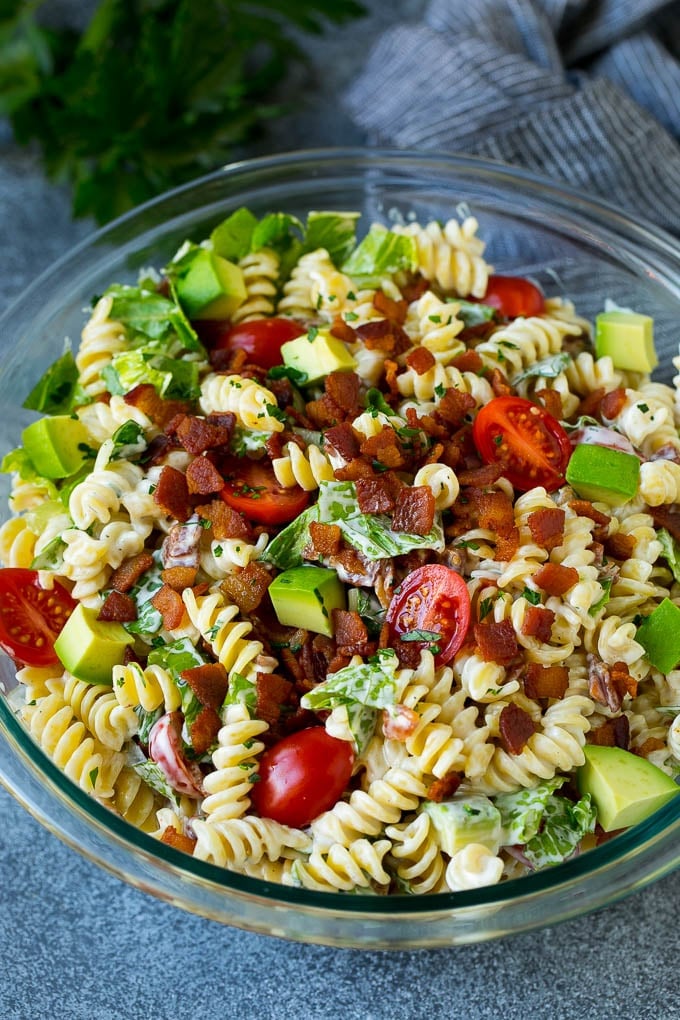 A bowl of BLT pasta salad with avocado in a creamy dressing.