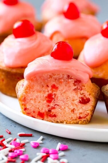 Cherry muffins studded with maraschino cherries and topped with pink glaze.