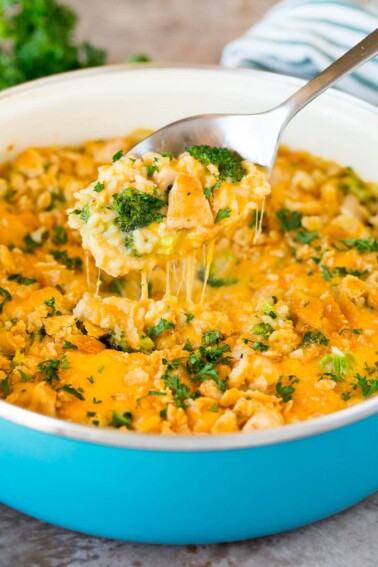 A spoon serving up a portion of cheesy chicken broccoli casserole.