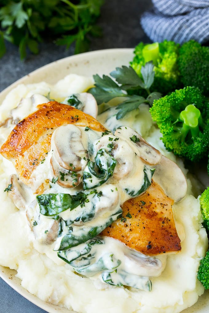 Chicken florentine served over mashed potatoes with broccoli.