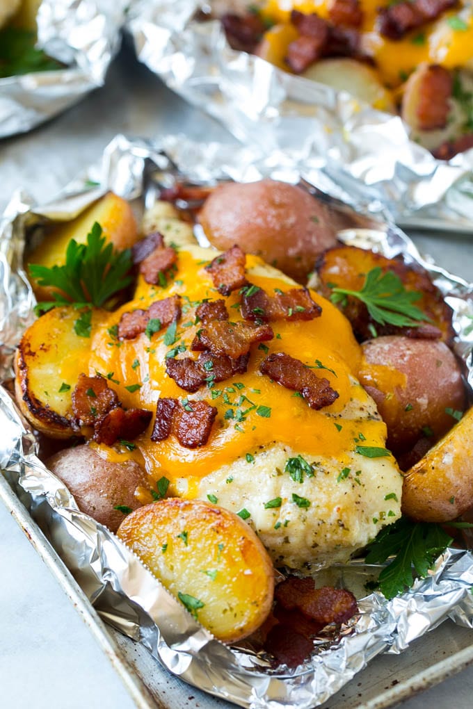 Chicken in foil topped with cheddar cheese and bacon.