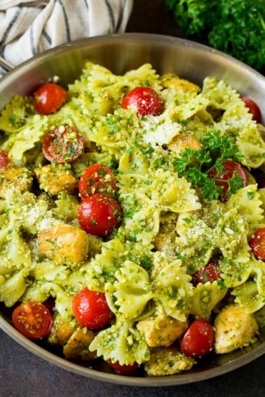 Chicken pesto pasta with cherry tomatoes and parmesan cheese.