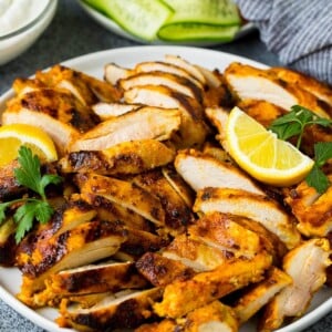 Sliced chicken shawarma garnished with parsley and lemon.