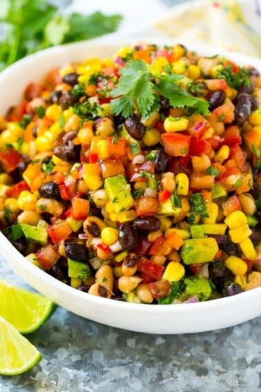 A serving bowl of cowboy caviar made with beans and veggies, and garnished with cilantro.