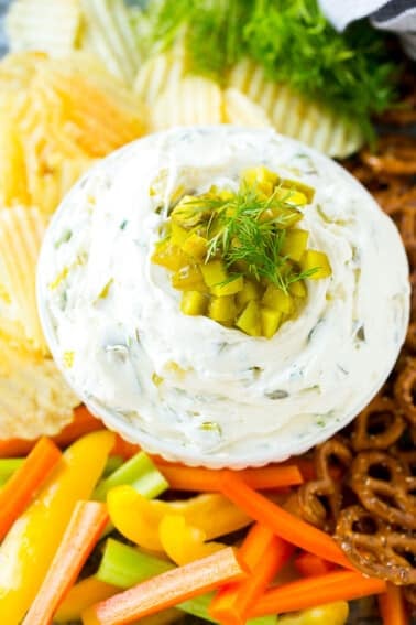 A bowl of dill pickle dip served with vegetables.