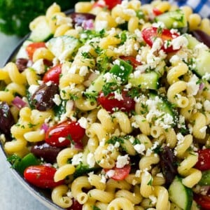 Greek pasta salad in a serving bowl, garnished with parsley.