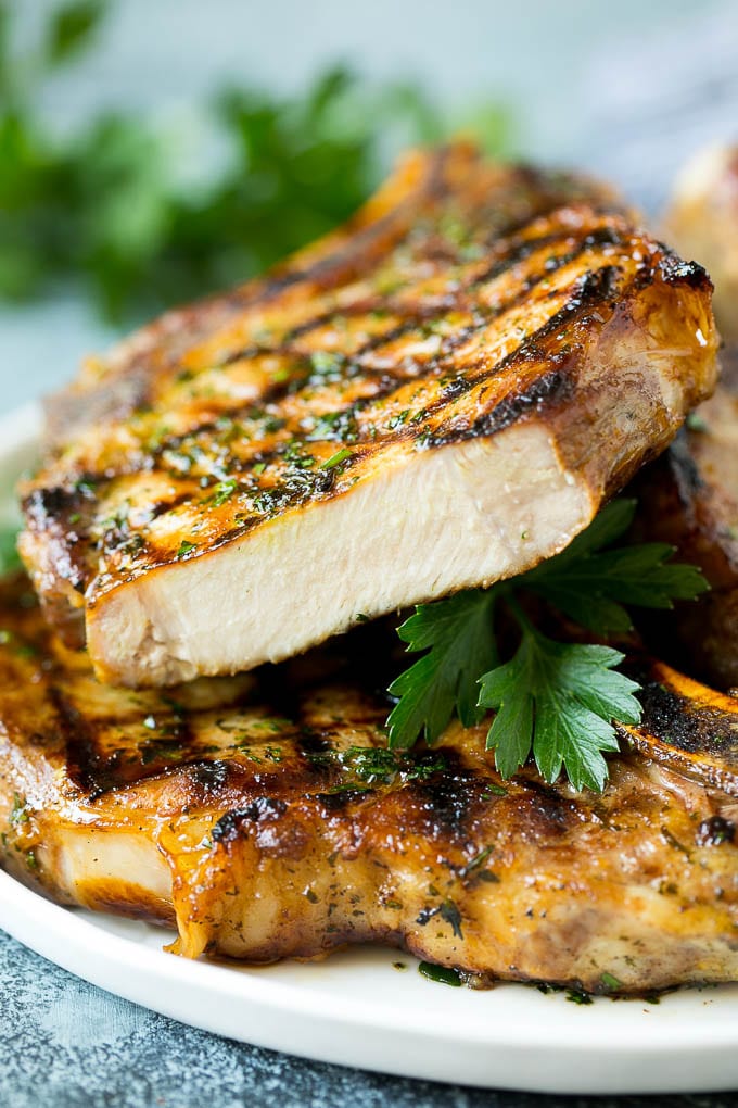 Grilled pork chops with a cut chop on top of the stack.