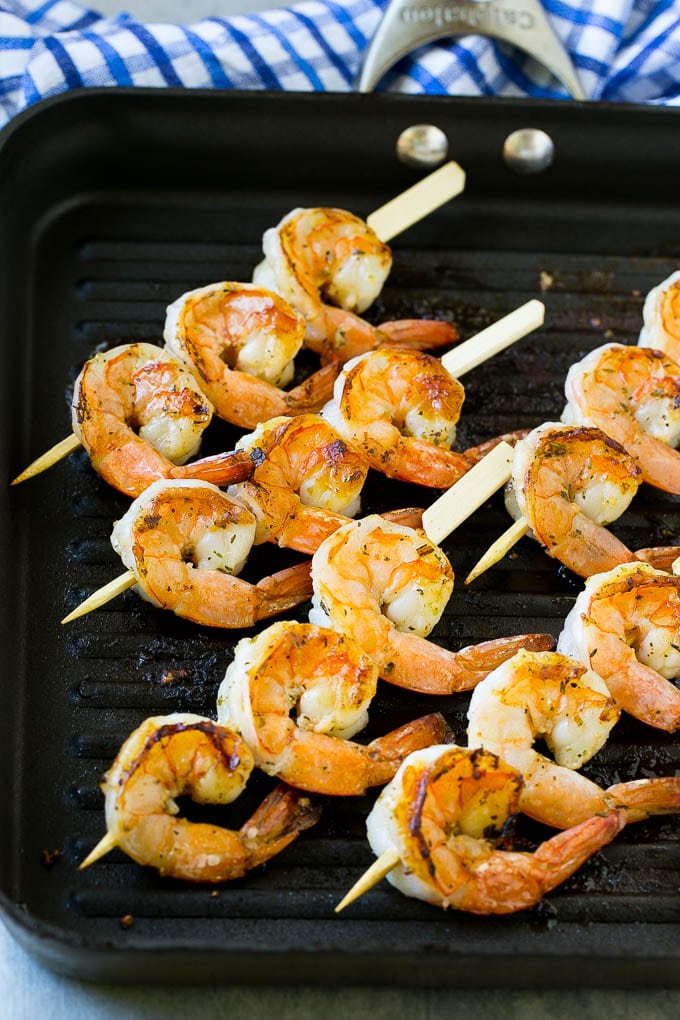 Shrimp skewers cooking on a grill pan.