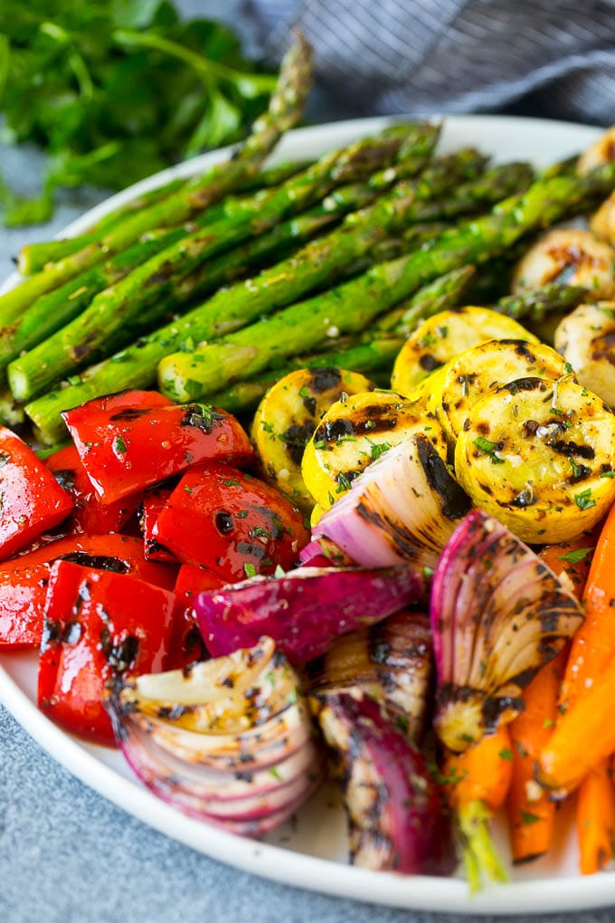 A platter of grilled veggies including peppers, onions and carrots.