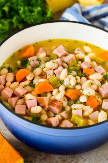 A pot of ham and beans garnished with parsley.
