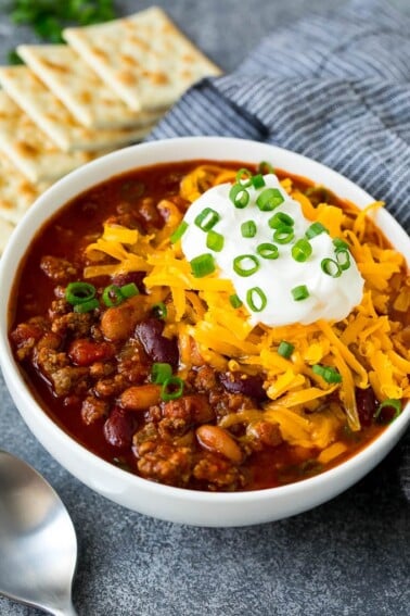A bowl of Instant Pot chili topped with sour cream, cheese and green onions.