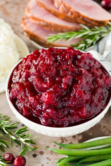 A bowl of Instant Pot cranberry sauce garnished with rosemary.