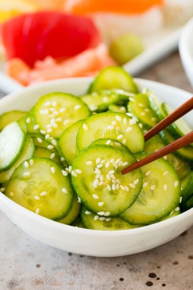 Chopsticks serving a portion of Japanese cucumber salad.