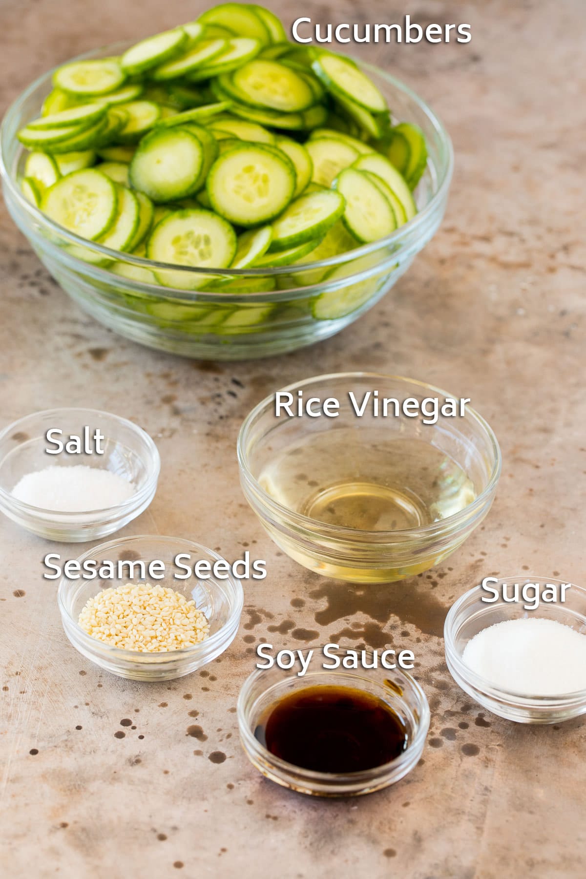 Bowls of cucumber, seasonings and soy sauce.