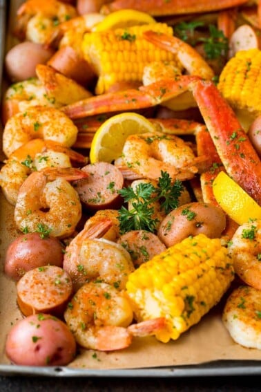 A Low Country Boil with shrimp, crab, sausage corn and potatoes on a sheet pan.