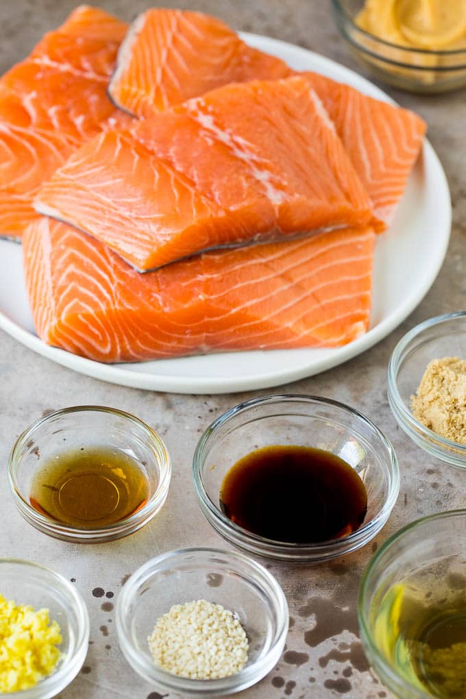 Salmon fillets with an assortment of ingredient bowls.