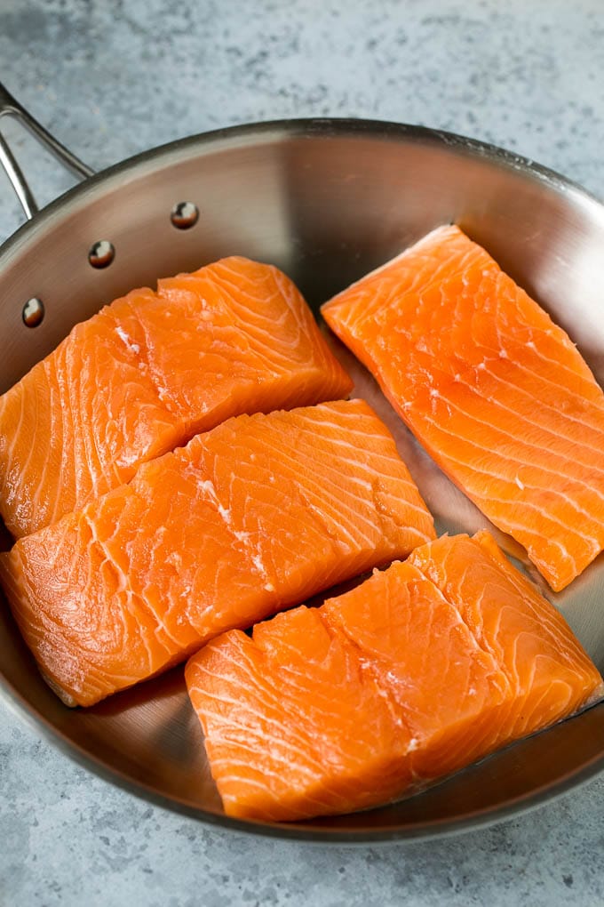 Raw salmon fillets in a pan.