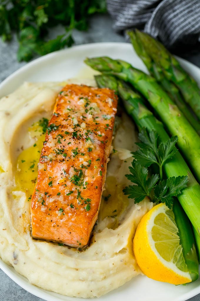 A pan seared salmon fillet served with mashed potatoes and asparagus.