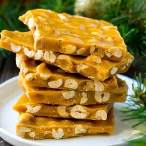 A stack of peanut brittle pieces on a serving plate.