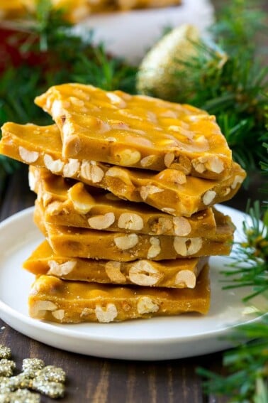 A stack of peanut brittle pieces on a serving plate.