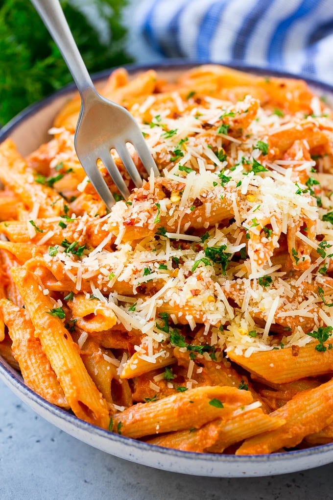 A bowl of penne alla vodka with a fork in it.