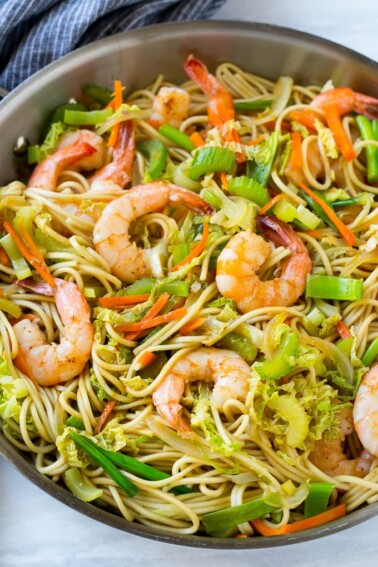 A pan of shrimp chow mein noodles with vegetables.