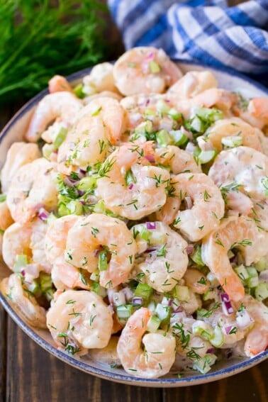 Shrimp salad in a serving bowl, topped with fresh dill.