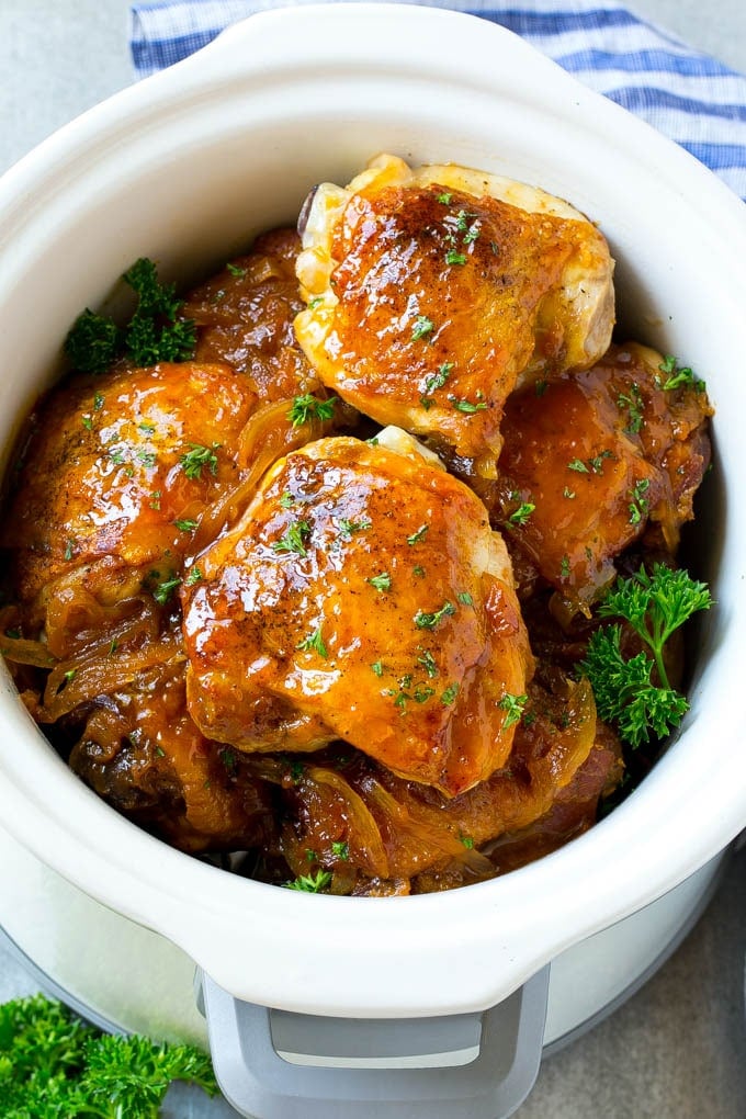 A slow cooker full of apricot chicken thighs.