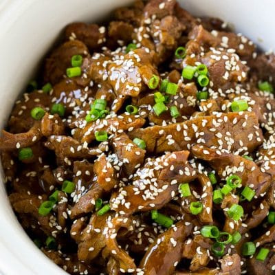 Slow cooker Korean beef with flank steak slices in a sweet and savory sauce, all inside a crock pot.