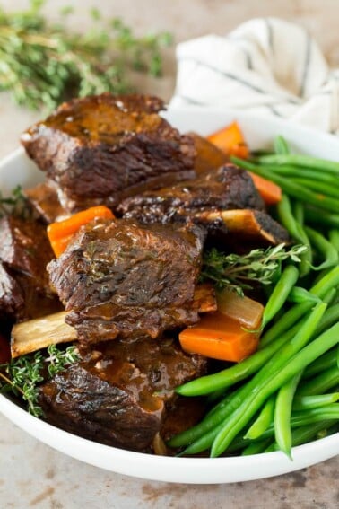 A serving bowl of slow cooker short ribs and green beans.