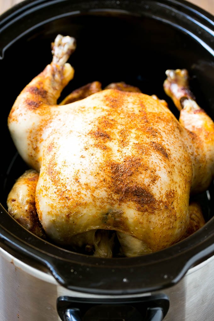 A cooked whole chicken in a slow cooker.