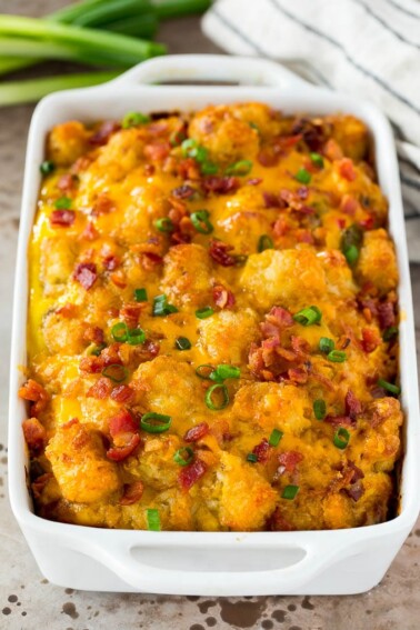 Tater tot breakfast casserole topped with bacon and green onions.